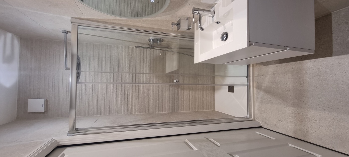 Finished Porcelanosa ensuite with shower enclosure, grey vanity and Porcelanosa tiles